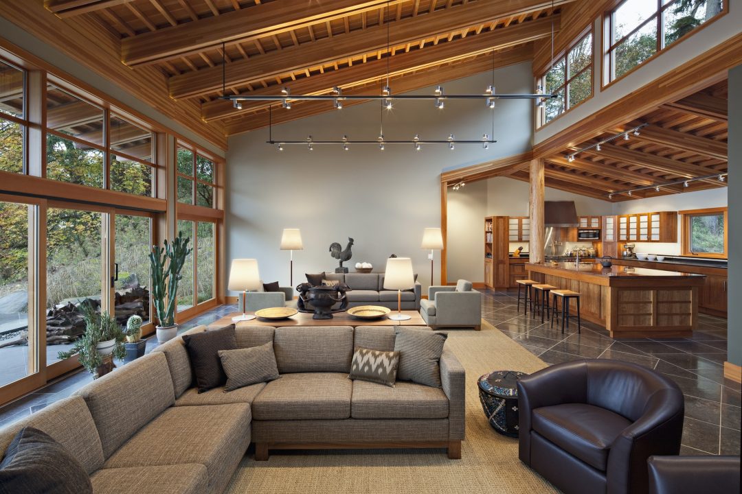 Modern open-plan interior with generous seating, timber ceiling, floor-to-ceiling windows and indoor plants — rooftop and indoor-outdoor restaurant design Bangladesh