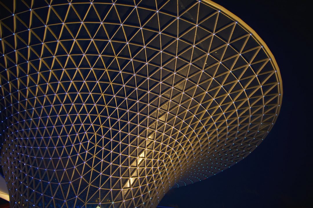 Modern glass commercial building at night — future of interior design Bangladesh 2026