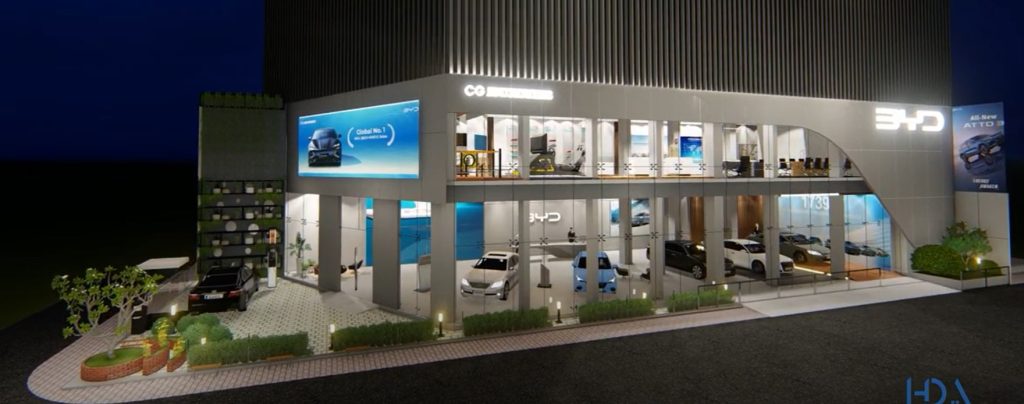 BYD showroom Dhaka exterior night render — two-storey glass curtain wall facade, vertical ribbed grey cladding, BYD LED signage, Global No.1 digital billboard, curved entry canopy, EV charging station in forecourt and landscaped grounds, House De Arch Bangladesh