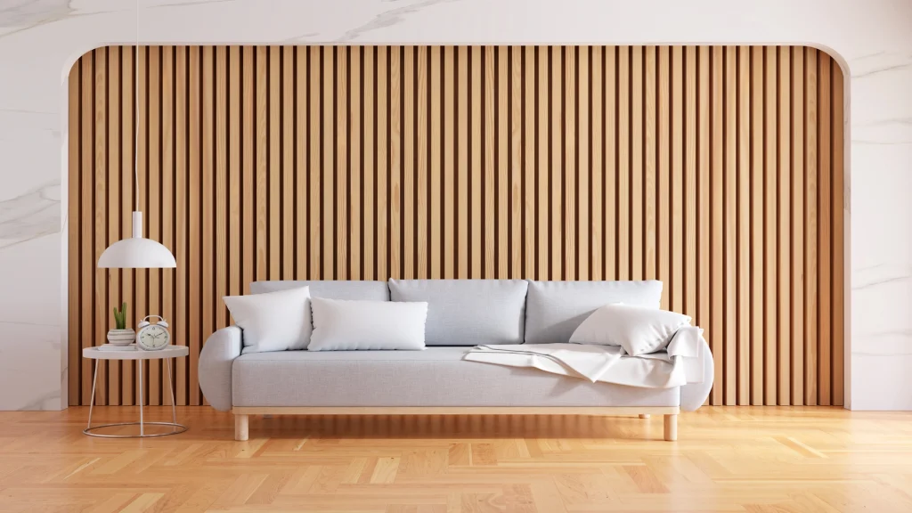 Japandi living room with vertical slatted timber feature wall, grey linen sofa, pendant lamp and timber floor — small space interior design Bangladesh showing how restraint creates spaciousness